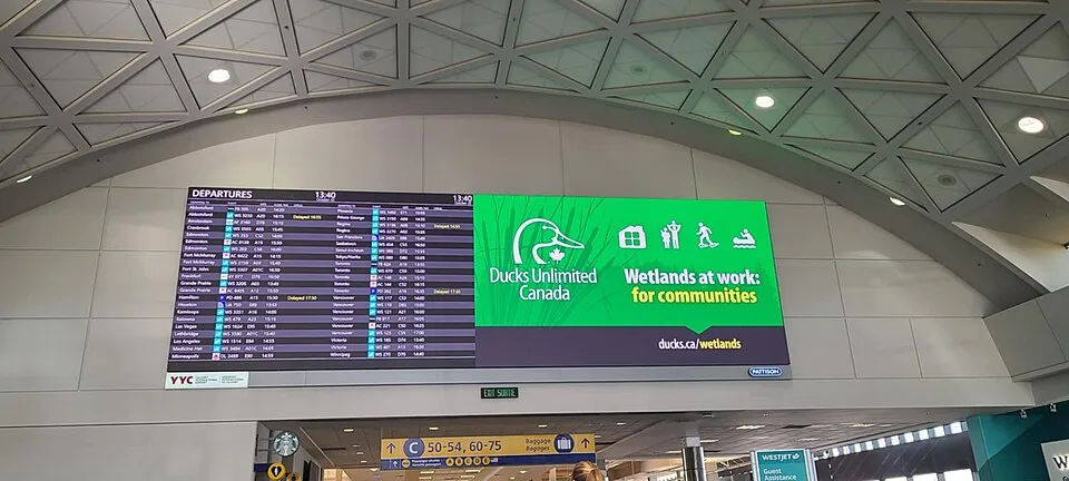 Context photograph: Departure board and directional signage at Calgary International Airport (YYC); signage context, not an identified product or supplier on this page.