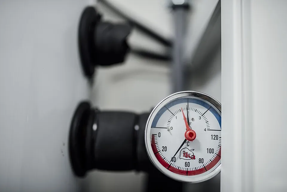 Context photograph: Pressure gauge shows measurement on equipment in a workshop setting with tools and machinery around it; science context, not an identified product or supplier on this page.