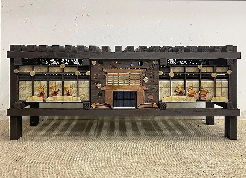 Context photograph: Goze Mokudon bench-shaped andon lantern with transparent wood panels, daytime front view; timber context, not an identified product or supplier on this page.