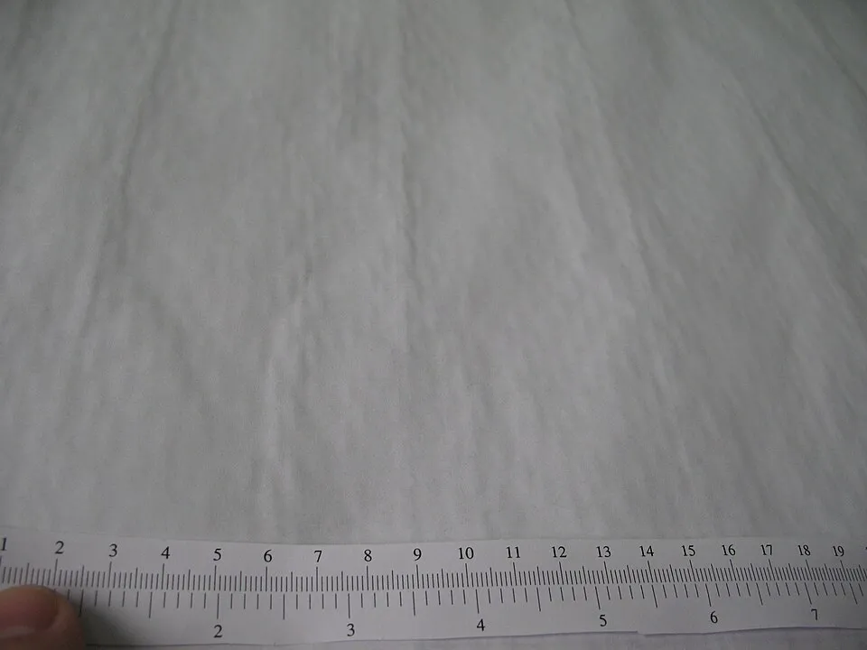 Context photograph: Cheap plotter paper soaked with ink - swelled fibers show papermaking mesh belt pattern; printing context, not an identified product or supplier on this page.